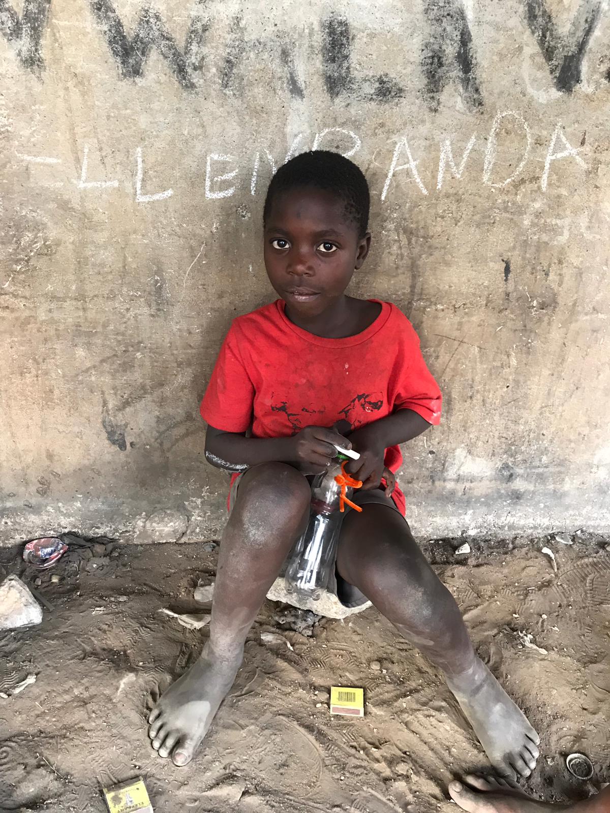 Street child sitting on the ground in Lusaka Zambia